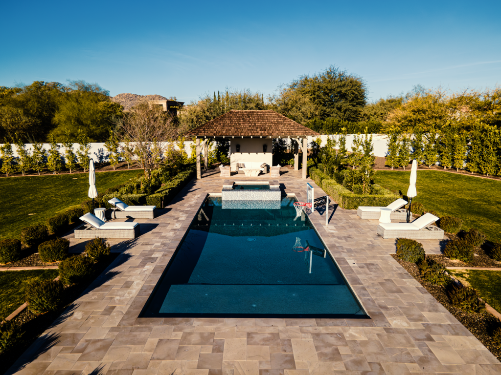 Aerial photo of luxury lap pool with travertine deck, cabana, and lush landscaping in Scottsdale Arizona built by Caribbean Pools