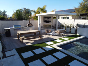 Thumbnail of http://Wide%20view%20of%20a%20covered%20outdoor%20lounge%20area%20with%20TV%20and%20fireplace%20near%20a%20built-in%20grill%20and%20pizza%20oven%20in%20a%20Phoenix%20backyard,%20part%20of%20an%20Arizona%20pool%20project.