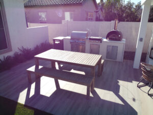 Thumbnail of http://Blurry%20view%20of%20an%20outdoor%20kitchen%20area%20in%20a%20modern%20Phoenix%20backyard%20with%20grill%20and%20pizza%20oven%20near%20a%20pool,%20part%20of%20a%20custom%20pool%20project%20by%20Arizona%20pool%20builders.