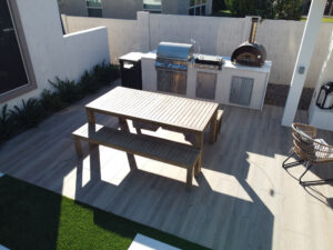 Thumbnail of http://Close-up%20view%20of%20an%20outdoor%20kitchen%20area%20featuring%20a%20built-in%20stainless%20steel%20grill,%20pizza%20oven%20and%20prep%20table%20on%20a%20patio,%20part%20of%20a%20custom%20pool%20backyard%20in%20Phoenix,%20Arizona%20designed%20by%20pool%20contractors.
