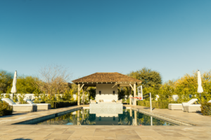 Symmetrical view of rectangular pool with cabana and travertine deck at luxury backyard in Scottsdale Arizona built by Caribbean Pools