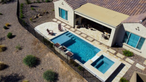 Thumbnail of http://Aerial%20view%20of%20rectangular%20pool%20with%20side%20entry%20steps,%20separate%20square%20spa%20and%20travertine%20patio%20in%20desert%20landscape%20at%20Chandler%20Arizona%20home%20built%20by%20Caribbean%20Pools
