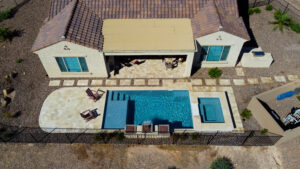 Thumbnail of http://Drone%20view%20of%20stylish%20backyard%20with%20rectangular%20pool,%20raised%20spa%20and%20travertine%20patio%20adjacent%20to%20desert%20home%20in%20Paradise%20Valley%20Arizona%20built%20by%20Caribbean%20Pools