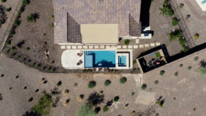 Thumbnail of http://Drone%20view%20of%20luxury%20backyard%20with%20rectangular%20pool,%20raised%20square%20spa%20and%20desert%20landscaping%20at%20custom%20home%20in%20Scottsdale%20Arizona%20built%20by%20Caribbean%20Pools