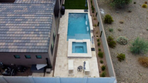 Bird's-eye view of narrow side-yard pool with square spa, travertine patio and desert landscaping in Phoenix Arizona built by Caribbean Pools