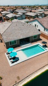 Thumbnail of http://Overhead%20view%20of%20backyard%20lap%20pool%20with%20sun%20shelf,%20umbrellas%20and%20lakeside%20canal%20in%20Gilbert%20Arizona%20built%20by%20Caribbean%20Pools