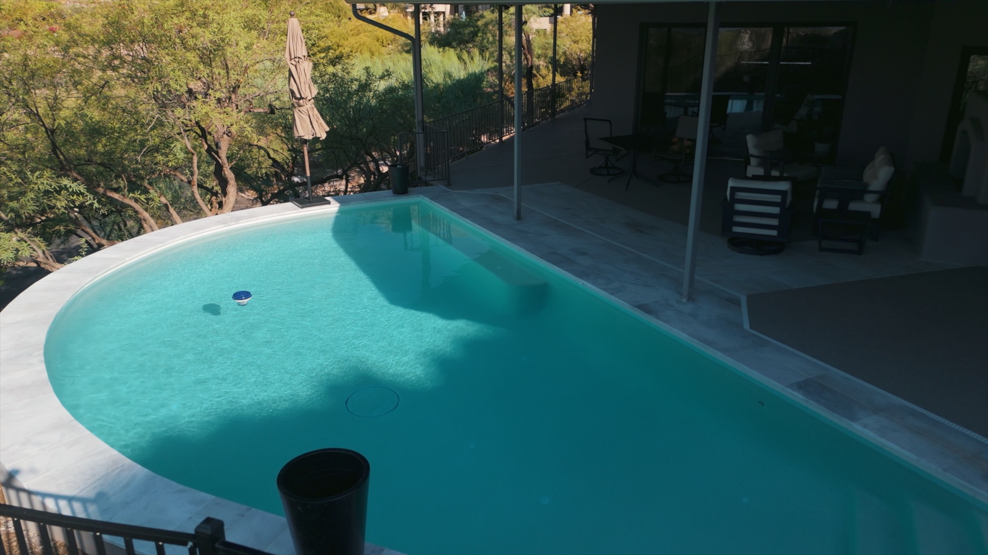Freeform Phoenix pool with tanning ledge and marble decking by Caribbean Pools